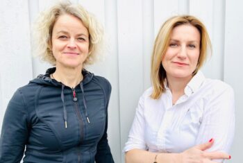 Anja Vaskinn og Natalia Tesli foran en hvit husvegg