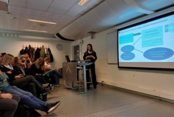 En foreleser snakker foran et publikum
